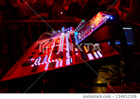 Vibrant concert audio setup, Energetic performance with glowing lighting and sound equipment, Colorful professional audio mixing environment during lively concert event Vibrant concert audio setup, Energetic performance with glowing lighting and sound equipment, Colorful professional audio mixing environment during lively concert event 134652106