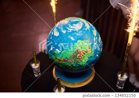 Luxurious earth themed cake showcased with sparkling fireworks and decorations, Extravagant celebration featuring world map cake illuminated with sparklers and ambient lighting Luxurious earth themed cake showcased with sparkling fireworks and decorations, Extravagant celebration featuring world map cake illuminated with sparklers and ambient lighting 134652150