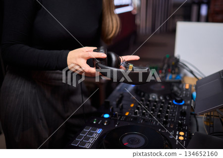 DJ setup overview, Energetic club DJ performing with digital controller in action, Content creator mixing music live using digital turntables under vibrant stage lights DJ setup overview, Energetic club DJ performing with digital controller in action, Content creator mixing music live using digital turntables under vibrant stage lights 134652160