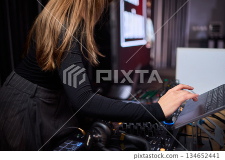 DJ setup overview, Energetic club DJ performing with digital controller in action, Content creator mixing music live using digital turntables under vibrant stage lights DJ setup overview, Energetic club DJ performing with digital controller in action, Content creator mixing music live using digital turntables under vibrant stage lights 134652441