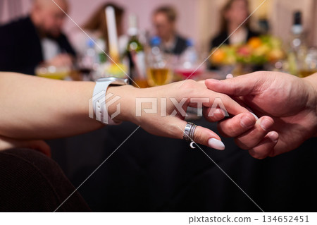 Friendly hand interlock, Close friends linked hands during joyful gathering, Intimate moment capturing friendship and reassurance with clasped hands during celebration Friendly hand interlock, Close friends linked hands during joyful gathering, Intimate moment capturing friendship and reassurance with clasped hands during celebration 134652451