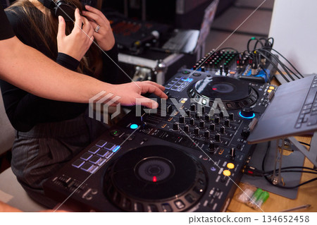 DJ setup overview, Energetic club DJ performing with digital controller in action, Content creator mixing music live using digital turntables under vibrant stage lights DJ setup overview, Energetic club DJ performing with digital controller in action, Content creator mixing music live using digital turntables under vibrant stage lights 134652458
