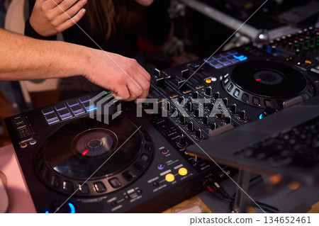 DJ setup overview, Energetic club DJ performing with digital controller in action, Content creator mixing music live using digital turntables under vibrant stage lights DJ setup overview, Energetic club DJ performing with digital controller in action, Content creator mixing music live using digital turntables under vibrant stage lights 134652461