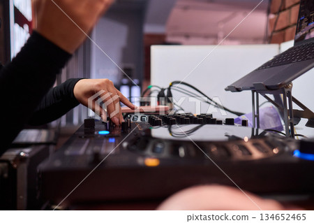 DJ setup overview, Energetic club DJ performing with digital controller in action, Content creator mixing music live using digital turntables under vibrant stage lights DJ setup overview, Energetic club DJ performing with digital controller in action, Content creator mixing music live using digital turntables under vibrant stage lights 134652465