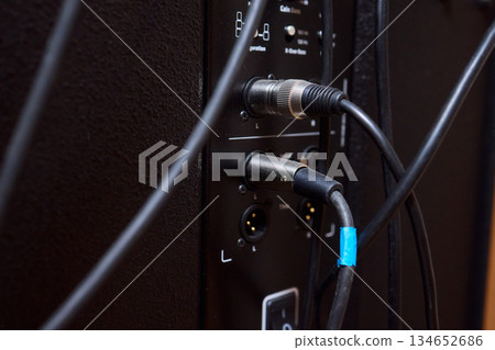 Audio gear setup, Closeup of durable professional sound hardware assembled for concert, Detailed shot displaying rugged stage audio equipment and control system in dim venue Audio gear setup, Closeup of durable professional sound hardware assembled for concert, Detailed shot displaying rugged stage audio equipment and control system in dim venue 134652686