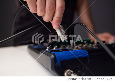 Fitting cables into professional studio gear, Attaching connectors carefully on live music setup, Ensuring accurate cable connections on audio production system 134652746