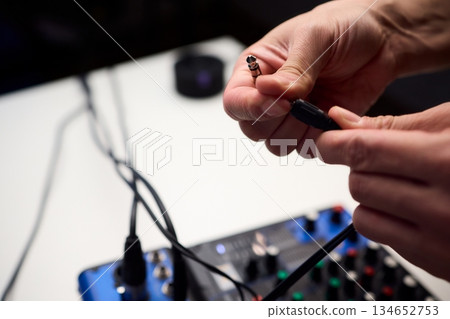 Audio setup preparation, Closeup images of connections during soundcheck setup process, Scene capturing stabilizing cables and adjusting controls before recording begins Audio setup preparation, Closeup images of connections during soundcheck setup process, Scene capturing stabilizing cables and adjusting controls before recording begins 134652753