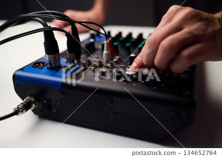 Closeup of audio control panel, Technician finetunes mixer controls and inspects connections, Focused technician performing maintenance on audio mixer controls and LEDs Closeup of audio control panel, Technician finetunes mixer controls and inspects connections, Focused technician performing maintenance on audio mixer controls and LEDs 134652764