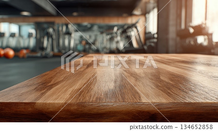 Smooth Wooden Table Surface in Modern Gym with Blurred Fitness Equipment 134652858