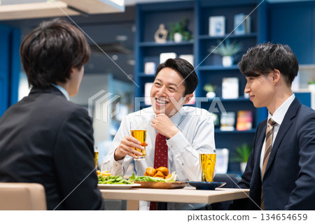 A middle-aged businessman having a drinking party with his subordinates A middle-aged businessman having a drinking party with his subordinates 134654659