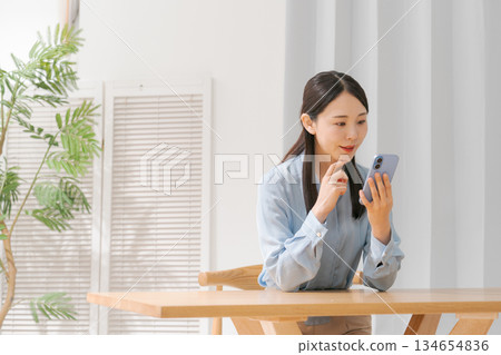 一個操作智能手機的年輕女子 134654836