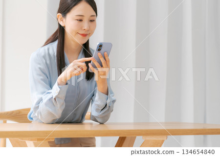 A young woman operating a smartphone A young woman operating a smartphone 134654840