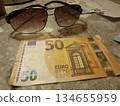 一張50歐元鈔票和一副太陽眼鏡，是在義大利一家飯店剪下來的。外幣讓你感覺彷彿置身國外。旅遊和金融業。 134655959