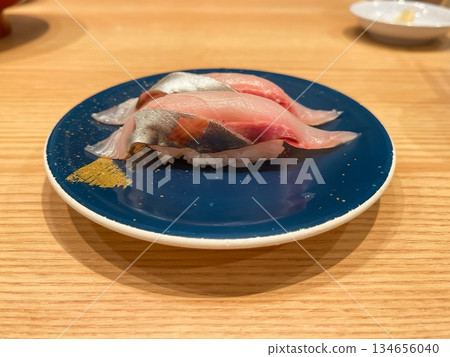 日本壽司。傳送帶壽司盤上的條紋傑克魚握壽司。 134656040
