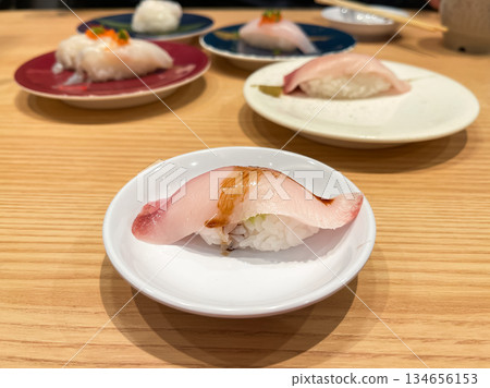 Japanese sushi, such as yellowtail nigiri sushi topped with fresh yellowtail sashimi. Japanese sushi, such as yellowtail nigiri sushi topped with fresh yellowtail sashimi. 134656153
