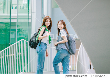 一名女大學生與朋友一起爬校園樓梯 134656540