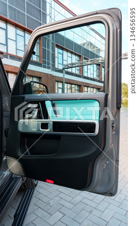 Car door showcasing modern design in a sleek urban environment Car door showcasing modern design in a sleek urban environment 134656595