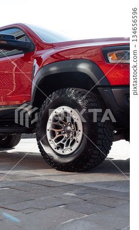 Off-road truck with bold tires parked on urban street under bright sunlight Off-road truck with bold tires parked on urban street under bright sunlight 134656596