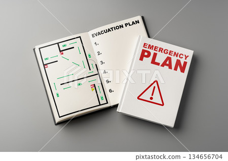 Emergency plan book with evacuation map and safety guidelines on a gray surface Emergency plan book with evacuation map and safety guidelines on a gray surface 134656704