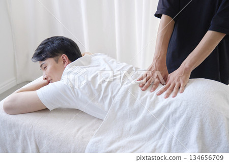 Man receiving a lower back massage Man receiving a lower back massage 134656709