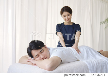 女按摩師正在為男士按摩下背部 134656711