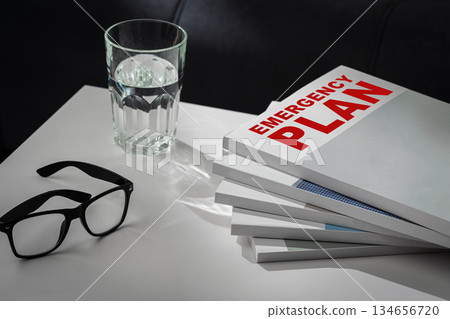 Preparing for safety with an emergency plan and glasses beside a glass of water 134656720