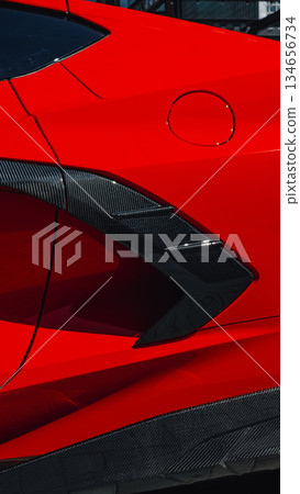 Bright red sports car highlighting sleek design and carbon fiber details in urban setting 134656734
