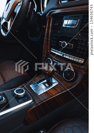 Detailed view of luxury car interior featuring wooden elements and modern controls Detailed view of luxury car interior featuring wooden elements and modern controls 134656745