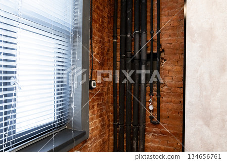 Exposed brick wall and pipes in modern urban interior design with natural light Exposed brick wall and pipes in modern urban interior design with natural light 134656761