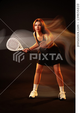 Tennis player preparing for a powerful shot in a dynamic setting 134656810