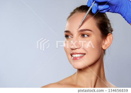 Woman receiving cosmetic treatment in clinic during morning hours for skin improvement Woman receiving cosmetic treatment in clinic during morning hours for skin improvement 134656839