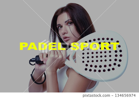 Young woman training in padel sport with a racket in a modern indoor setting Young woman training in padel sport with a racket in a modern indoor setting 134656974