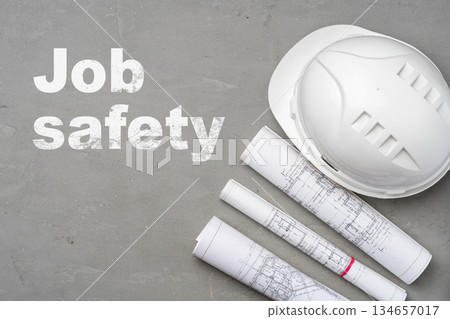 Construction workers focus on job safety with hard hat and plans 134657017