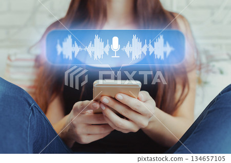 Young person sends voice message using smartphone in casual environment with focus on interaction 134657105