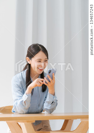 A young woman operating a smartphone A young woman operating a smartphone 134657243
