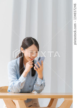 A young woman operating a smartphone A young woman operating a smartphone 134657246