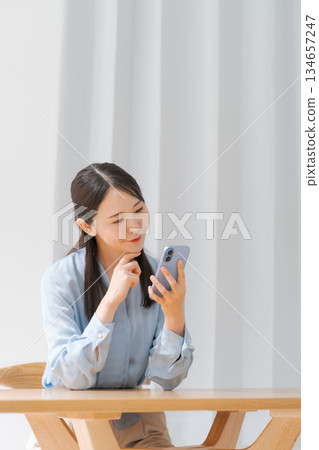 A young woman operating a smartphone A young woman operating a smartphone 134657247