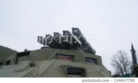 four-tube rocket launcher mounted on armored turret roof, angled upward against cloudy sky, armored hatch and tube cluster convey rugged ordnance readiness and museum display vibe. 134657788