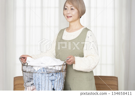 Senior woman doing housework laundry Senior woman doing housework laundry 134658411