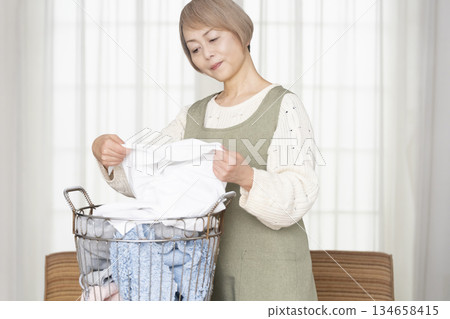 Senior woman doing housework laundry Senior woman doing housework laundry 134658415