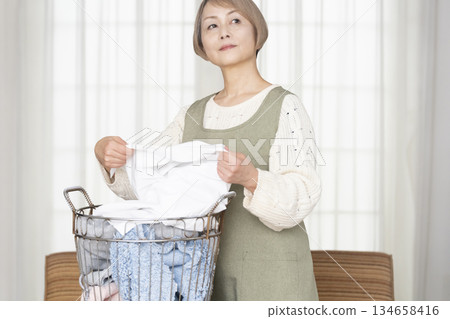 Senior woman doing housework laundry Senior woman doing housework laundry 134658416