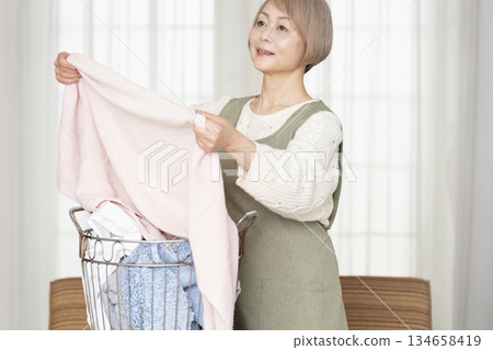 Senior woman doing housework laundry Senior woman doing housework laundry 134658419