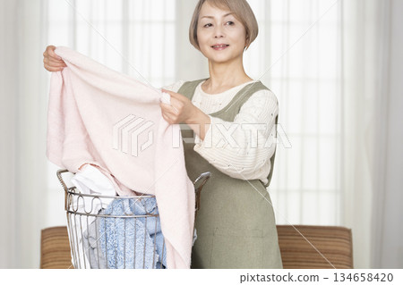 Senior woman doing housework laundry Senior woman doing housework laundry 134658420