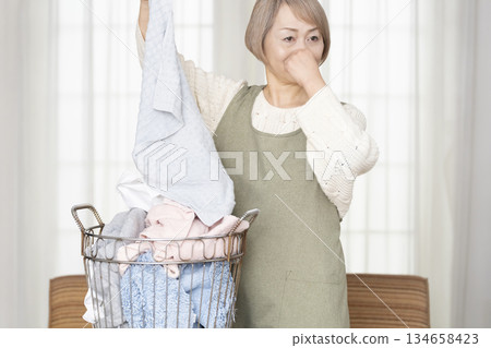 Senior woman doing housework laundry Senior woman doing housework laundry 134658423