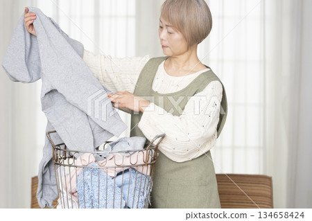 Senior woman doing housework laundry Senior woman doing housework laundry 134658424