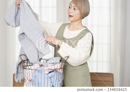 Senior woman doing housework laundry Senior woman doing housework laundry 134658425