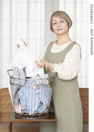 Senior woman doing housework laundry Senior woman doing housework laundry 134658428