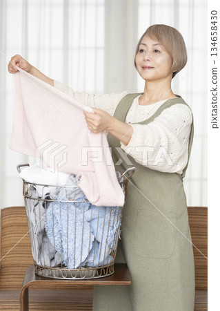 Senior woman doing housework laundry Senior woman doing housework laundry 134658430