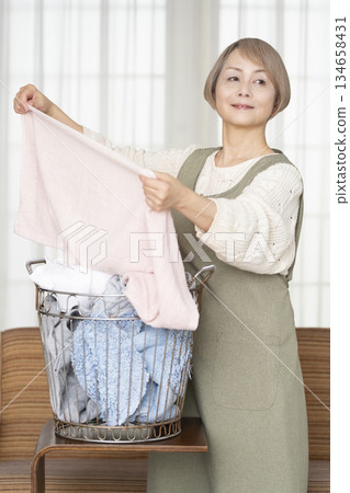 Senior woman doing housework laundry Senior woman doing housework laundry 134658431