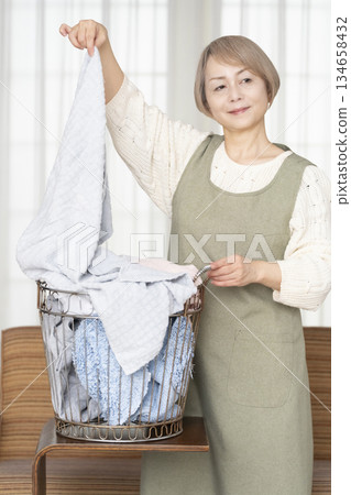 Senior woman doing housework laundry Senior woman doing housework laundry 134658432
